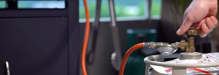 Person dreht Ventil an Gasflasche